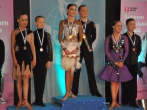 Juniori-ikäsarjan latinalaistanssien kärkikolmikko palkintokorokkeella