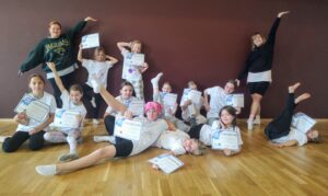 Lapsia ja nuoria iloitsee diplomit käsissä.