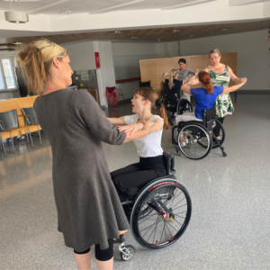 Tanssipareja joissa toinen osapuoli istuu pyörätuolissa.