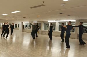 Mustissa vaatteissa yksin tanssivia ihmisiä.