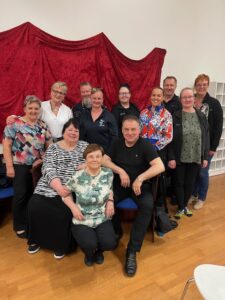 Ryhmäkuva jossa iloisia miehiä ja naisia.