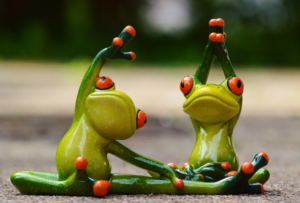 Kaksi keraamista sammakkoa venyttelee.