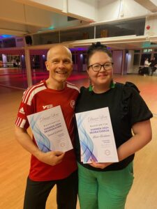 Mies ja nainen poseeraa diplomit kädessä.