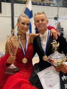 Nuori vakiotanssien voittajapari ja pokaalit.