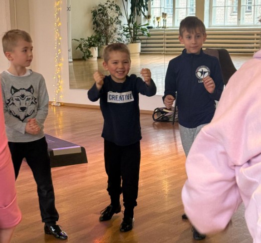 Kolme pientä poikaa tanssimassa