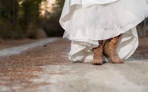 Cowgirl tiellä jalassaan buutsit ja pitkä mekko