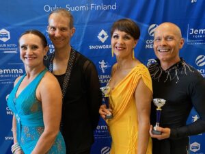 Kaksi senioriparia hymyilee ja poseeraa kameralle